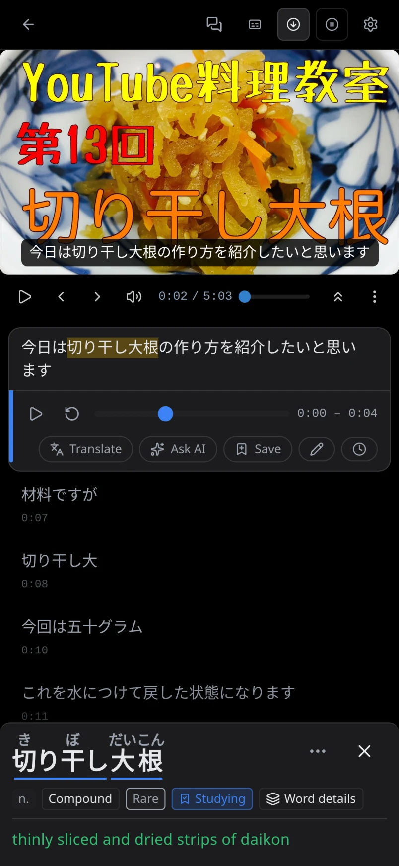 A Japanese cooking video paused on a caption with 切り干し大根 highlighted and its word inspector open, showing the meaning "thinly sliced and dried strips of daikon".